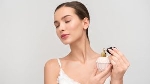Mlada žena prska parfem